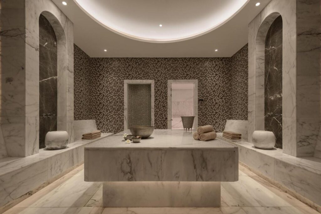 Mramorem obložená místnost ve spa hotelu JAZ Elite Riviera s velkým kamenným stolem uprostřed