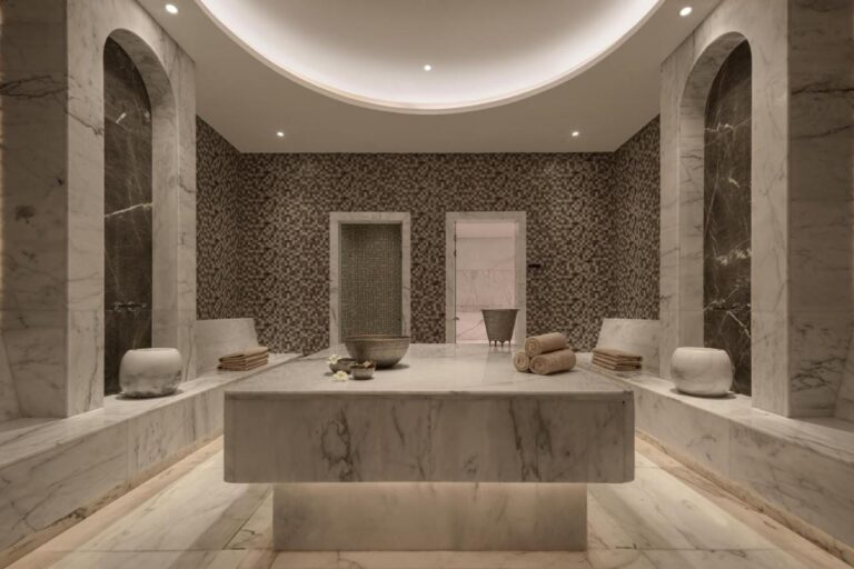 Mramorem obložená místnost ve spa hotelu JAZ Elite Riviera s velkým kamenným stolem uprostřed