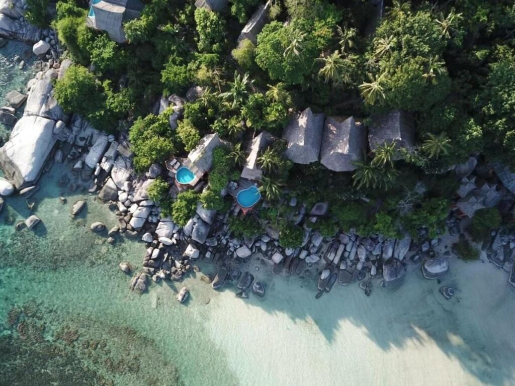 Letecký pohled na Koh Tao Cabana, jeho chatky mezi stromy, skály a pláž s bílým pískem