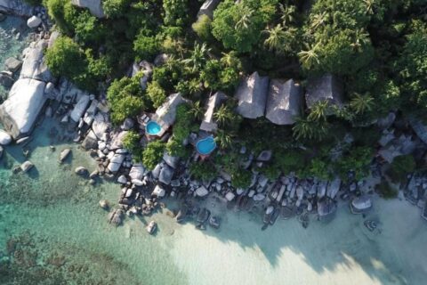 Letecký pohled na Koh Tao Cabana, jeho chatky mezi stromy, skály a pláž s bílým pískem