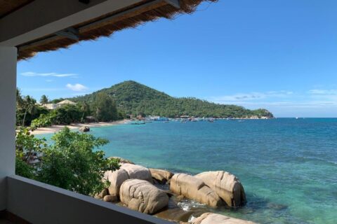 Zátoka se skalami a kotvícími loděmi z kryté terasy hotelu Koh Tao Heritage