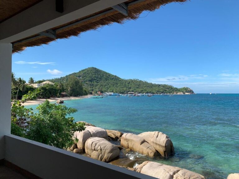 Zátoka se skalami a kotvícími loděmi z kryté terasy hotelu Koh Tao Heritage