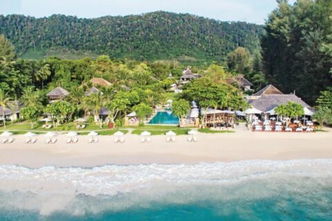 Layana Resort z moře, s pláží, bílými slunečníky, bazénem a střechami pod palmami