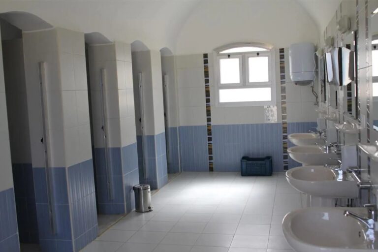 Sociální zařízení s řadou kabin a umyvadel