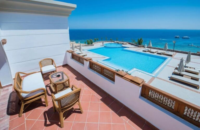 Terasa s ratanovým nábytkem nad velkým bazénem a Rudým mořem v Reef Oasis Beach Resort