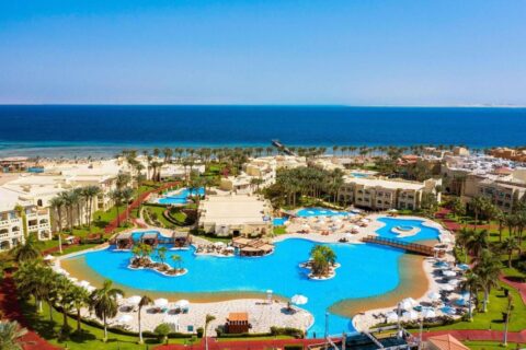 Letecký pohled na Rixos Sharm El Sheikh, jeho bazény ve tvaru laguny, palmy a Rudé moře