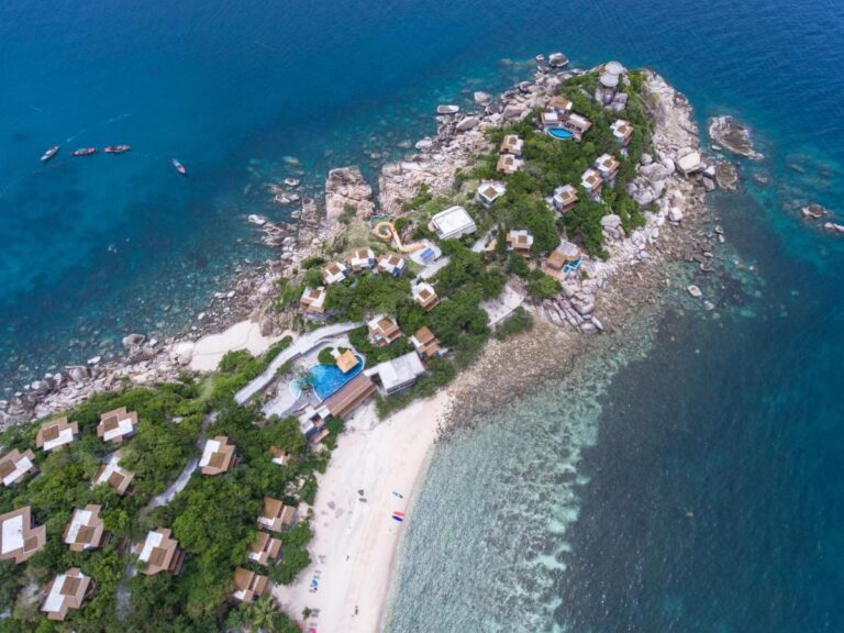 Letecký pohled na Sai Daeng Resort, jeho bungalovy na skalnatém výběžku, bazény a písečnou pláž