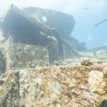 Přední nástavby vraku Thistlegorm pokryté tvrdými korály, při pohledu z paluby