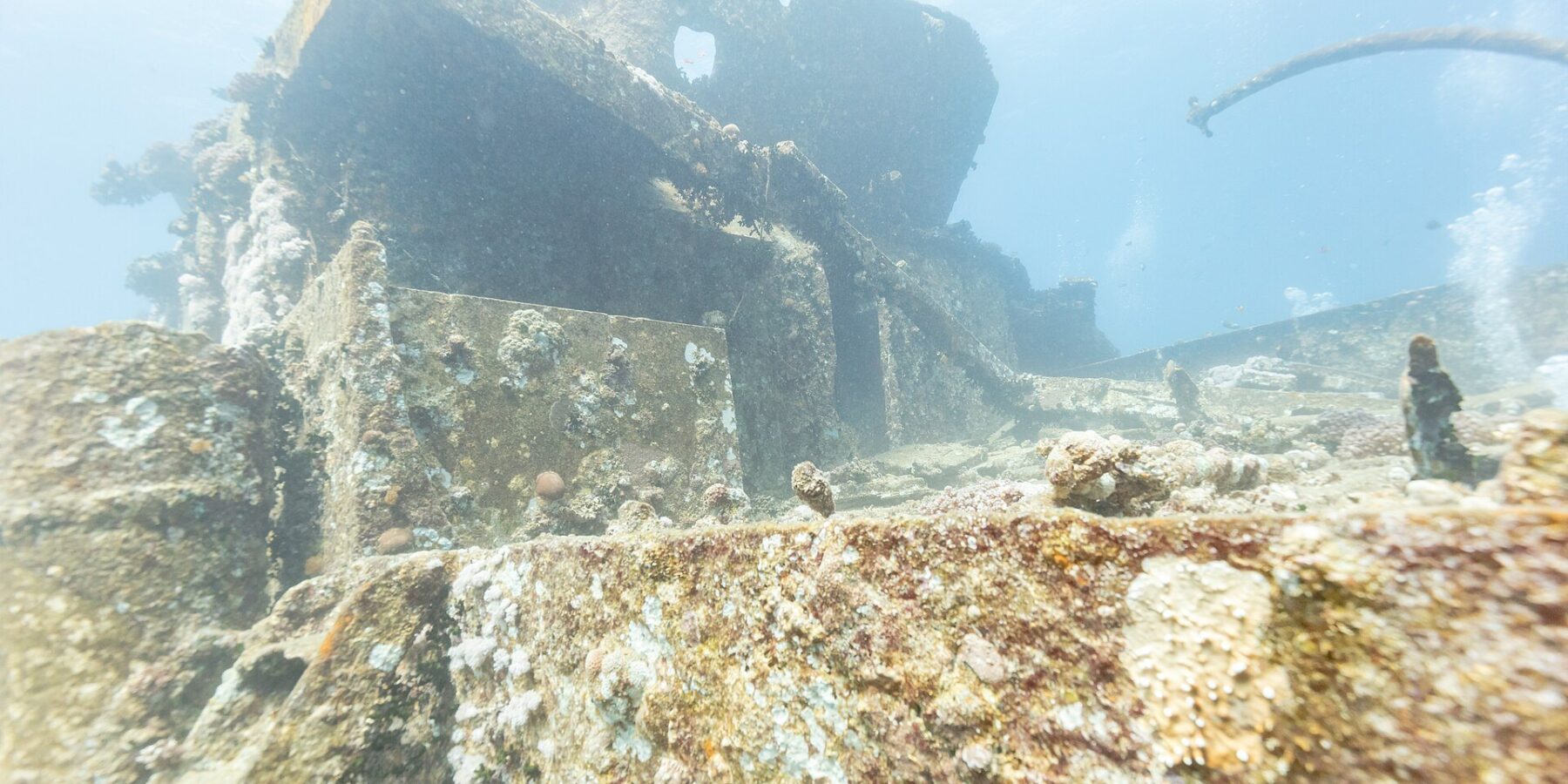 Přední nástavby vraku Thistlegorm pokryté tvrdými korály, při pohledu z paluby
