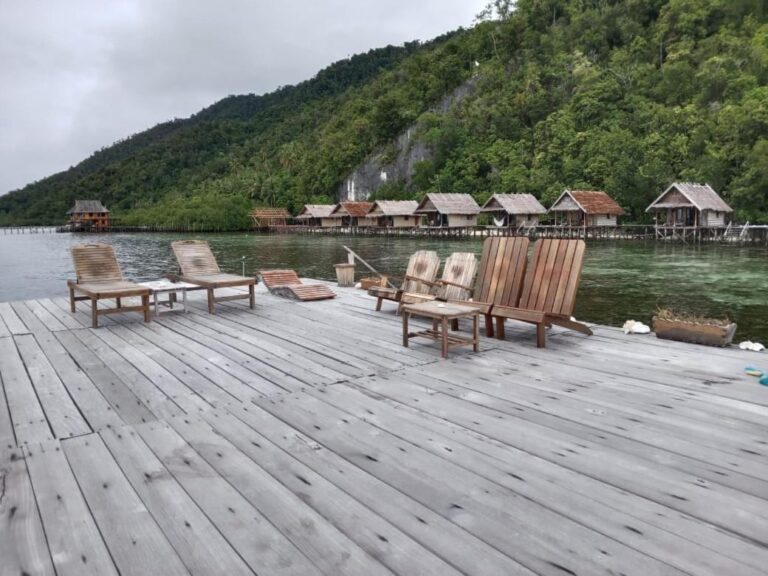 Lehátka na molu za šedého počasí, před bungalovy a kopcem