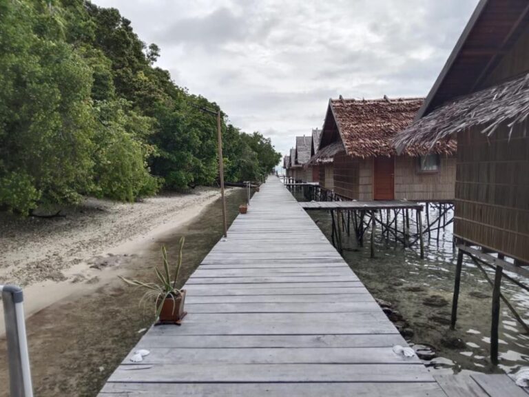 Dřevěná lávka mezi pláží a bungalovy na kůlech